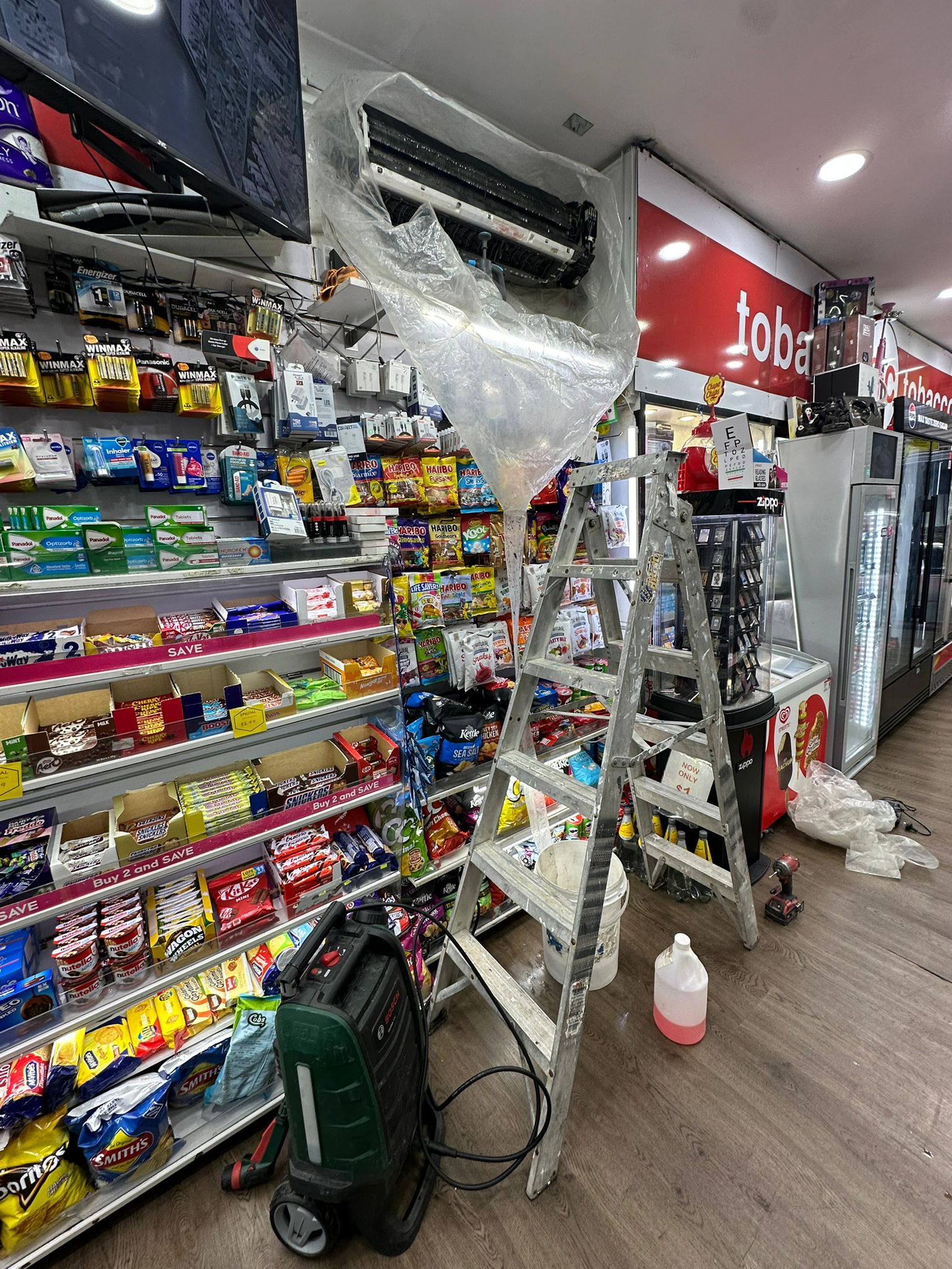 Toptech Air technician cleaning air conditioner filters during a scheduled maintenance visit in Sydney