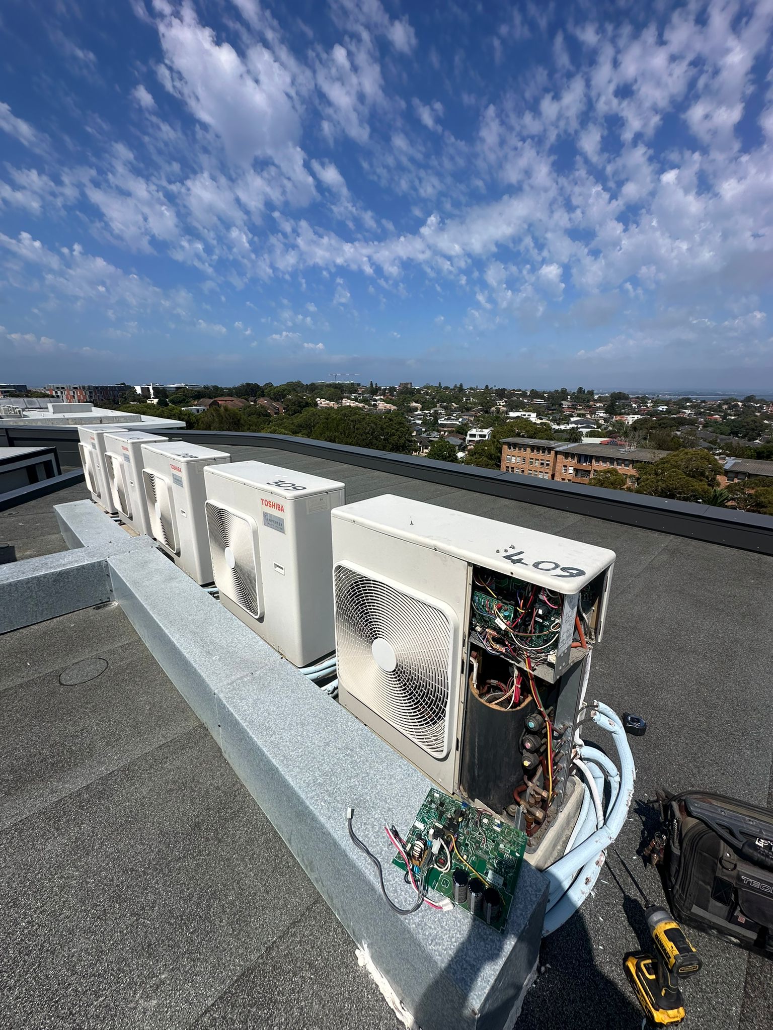 Toptech Air technician diagnosing and repairing a faulty air conditioning unit in a Sydney home